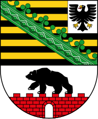 Wappen von Sachsen-Anhalt: Adler, schwarz-goldene Streifen mit grünem Rautenkranz und schwarzer Bär auf roter Mauer